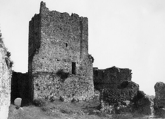 Torre de menagem do Castelo de Pombal em grande plano, com alvenaria de pedra e coroação em ruínas, em fotografia a preto e branco.